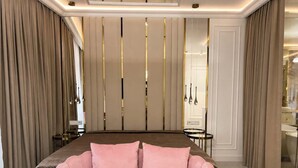 Ein Schlafzimmer mit einem Bett, einem rosa Sofa und einem Spiegel.