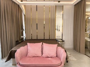 A bedroom with a bed, a pink sofa, and a mirror. - Granaria B209A | Jacuzzi | Best Location (Gdańsk)