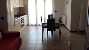 A compact living space with a kitchenette, a dining area, and a seating area. - Lorella's House (Terni)