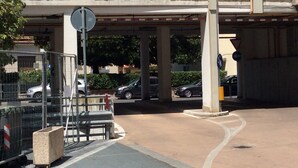 A building with a covered parking area, a pedestrian crossing, and a metal fence. - Lorella's House (Terni)