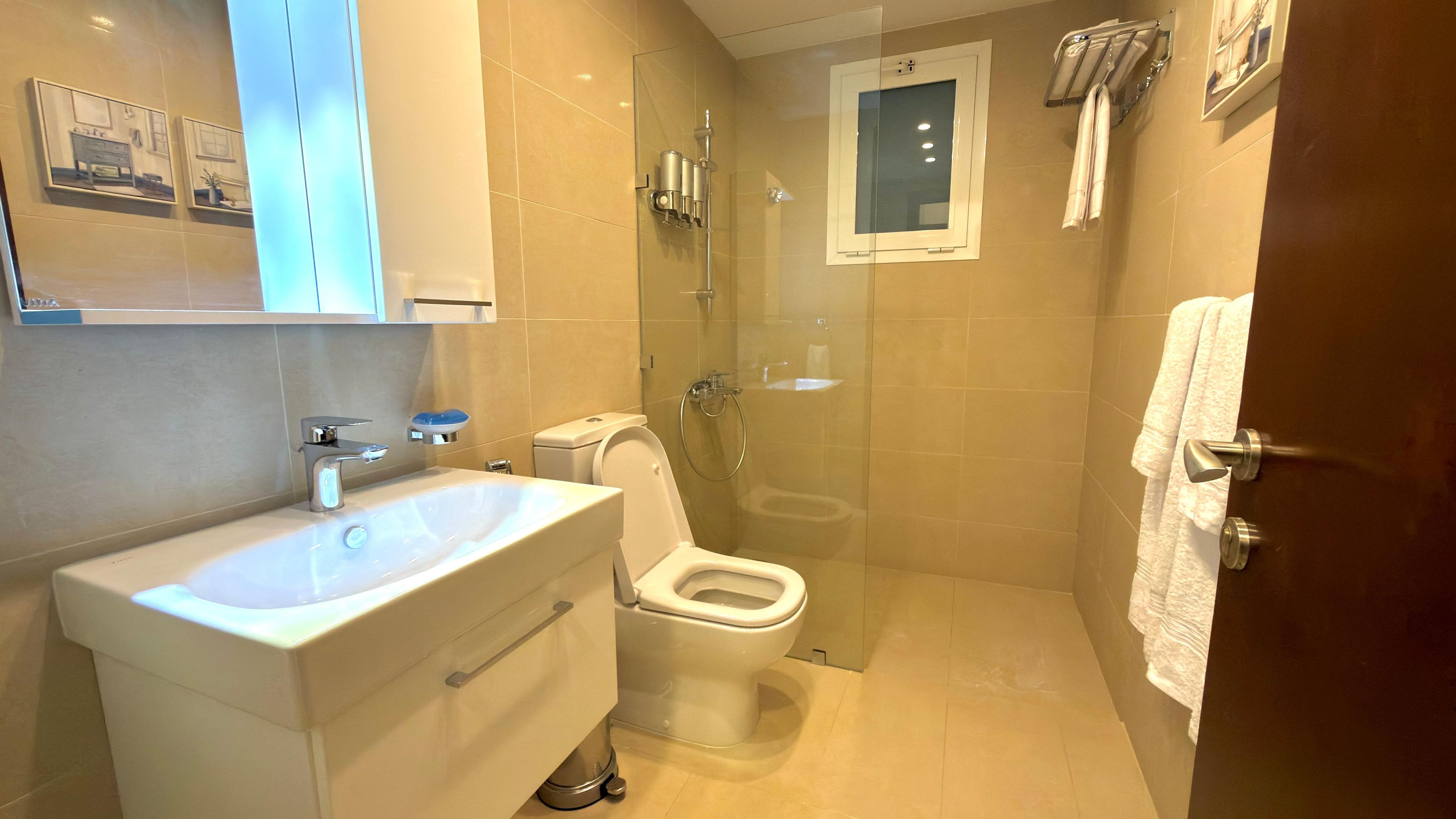 A bathroom with a sink, toilet, and shower.