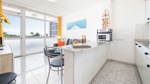 Una cucina moderna con zona pranzo, vista mare e decorazioni a tema surf.
