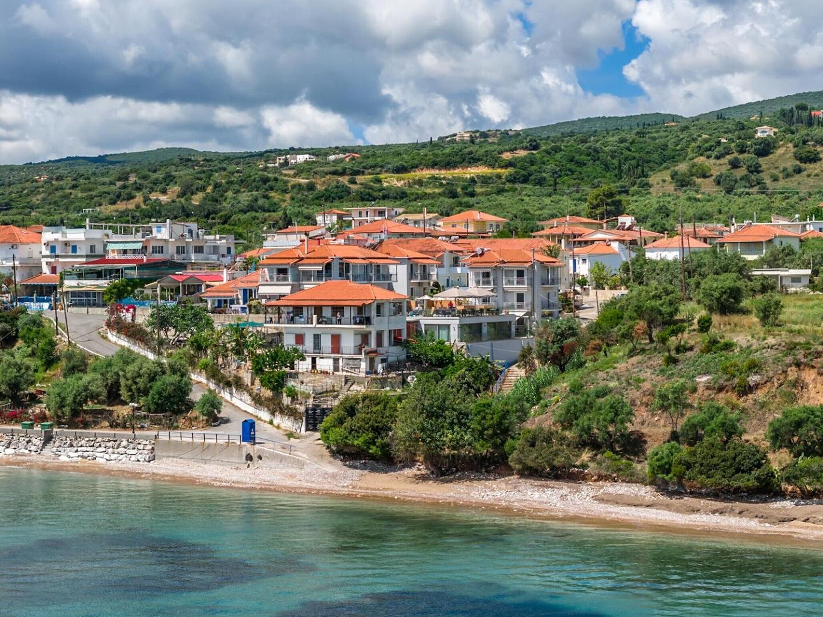 Ein Küstendorf mit terrassenförmig angelegten Häusern, einem Strand und klarem Wasser.