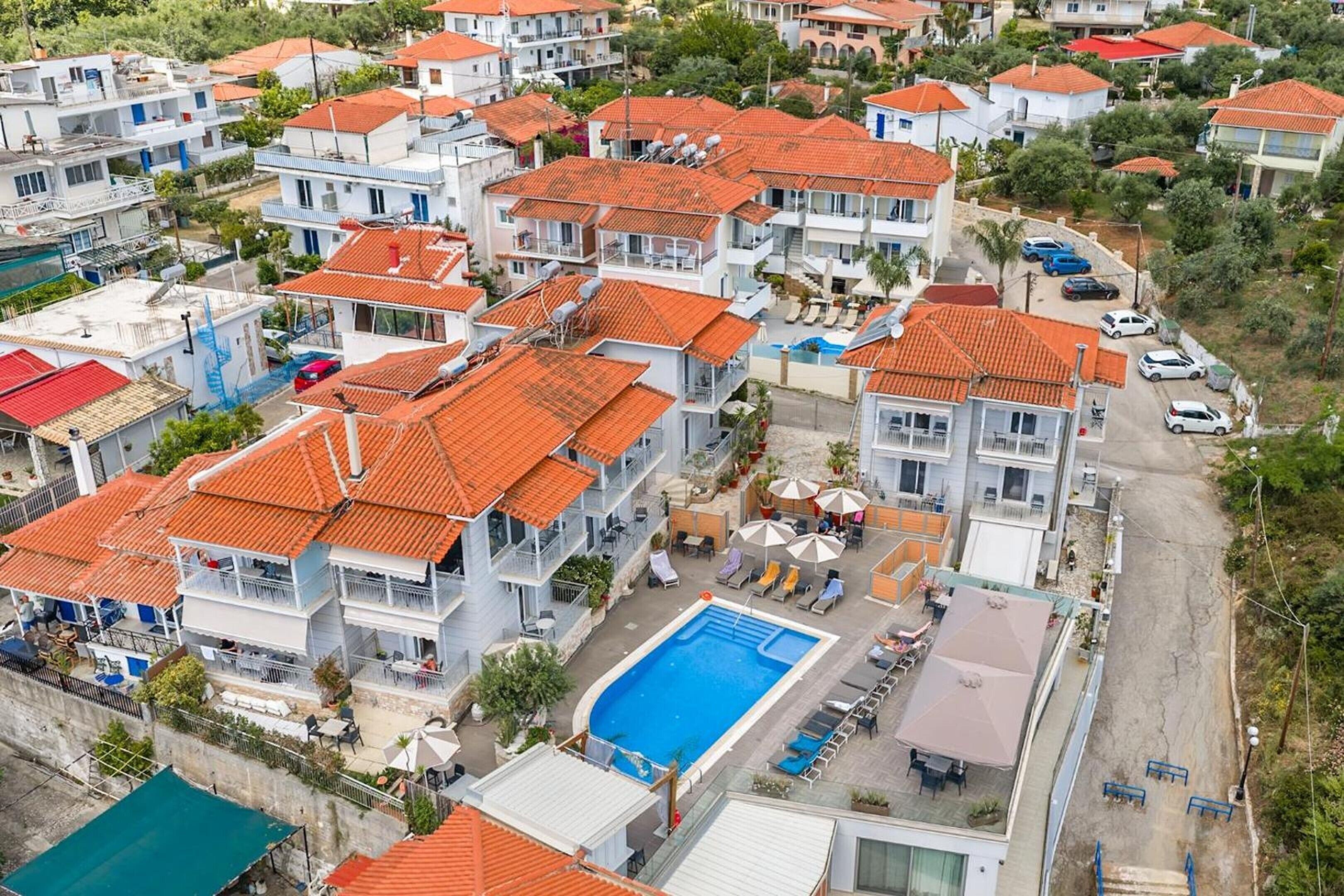 Un quartier résidentiel composé de plusieurs maisons à deux étages, chacune ayant un toit recouvert de tuiles rouges et dotée de balcons.