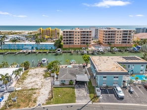 A coastal hotel with multiple buildings, a marina, and a beach view. - WTR FRONT Home W/Dock | Steps to the Beach! (Treasure Island)