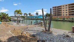 A marina with boats, a dock, and a building with balconies.