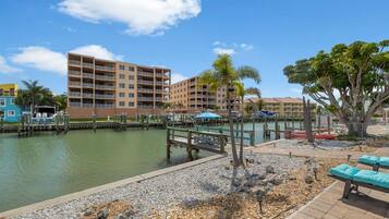 A marina with boats, a dock, and a building with multiple balconies.