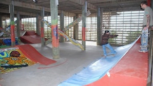 An indoor skate park with ramps and a long blue surface. - Ocean Lakes Beach House | Ocean View | Free Golf Cart | Sleeps 6 (Myrtle Beach)