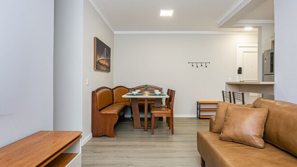 Een moderne woonkamer met een eethoek, een bank, een lange bank en een koelkast.