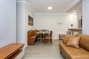 Un salon moderne comprenant un coin repas, un canapé, un banc et un réfrigérateur.