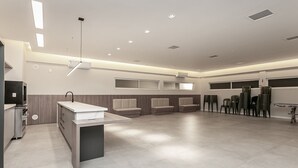 Een ruime, moderne keuken met een centraal eiland, ingebouwde zitplaatsen en een eethoek met stoelen.