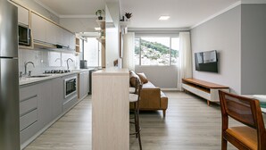 Een modern appartement met keuken, eethoek en woonkamer.