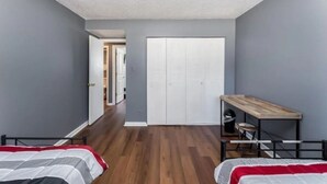 A bedroom with a bed, a desk, and a wardrobe. - Sleek & Peaceful Retreat at Bailey Court #1 (El Dorado)