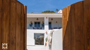 A wooden gate leading to a building with a white facade and multiple windows. - Villa ALMASUR by Abahana Villas (Benissa)