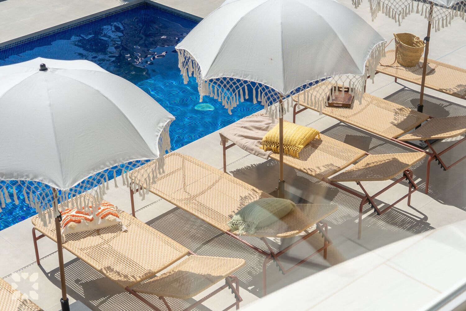 Ein Poolbereich auf dem Dach mit Liegestühlen und Sonnenschirmen.