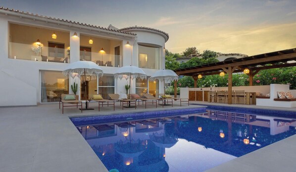 A modern poolside area with lounge chairs, umbrellas, and a pool. - Villa ALMASUR by Abahana Villas (Benissa)