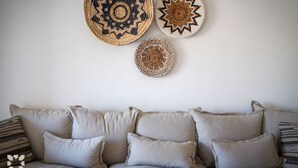 A living room with a sofa and three wall hangings. - Villa ALMASUR by Abahana Villas (Benissa)