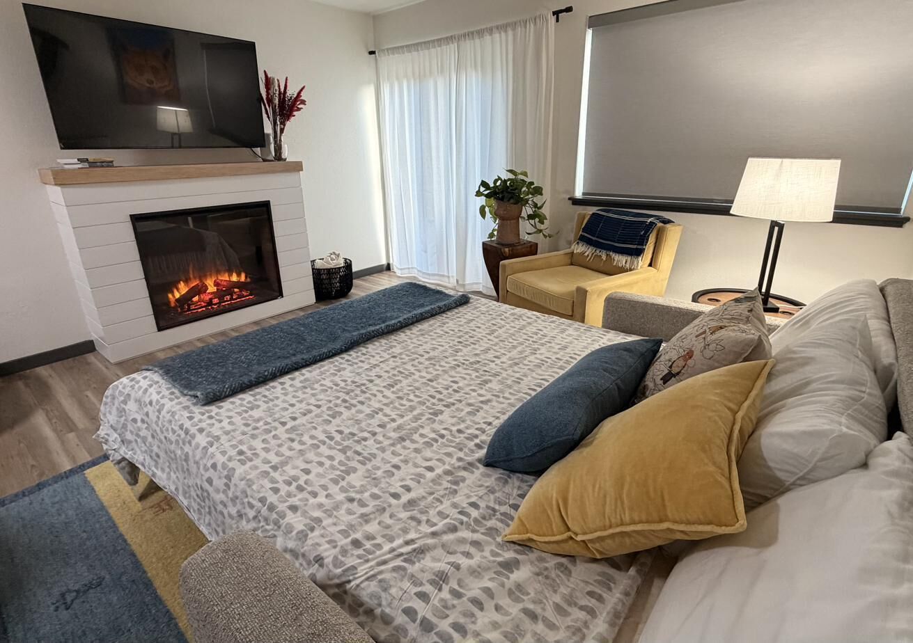 American Leather sleeper opens to comfy bed by fireplace & TV.