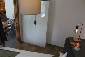 Une chambre avec un lit, une table où le petit-déjeuner est servi, une armoire et une lampe.