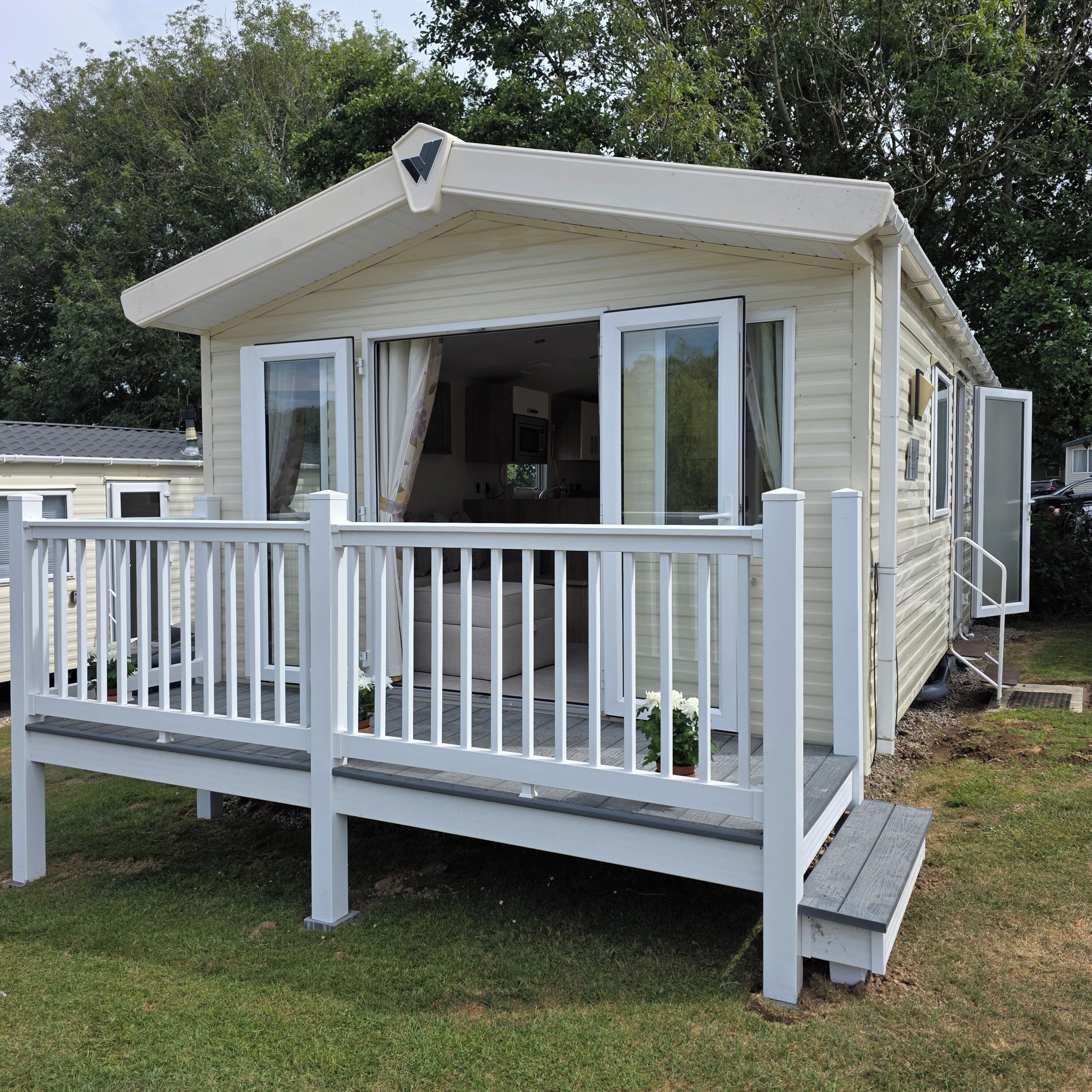 A mobile home with a deck and a small porch.