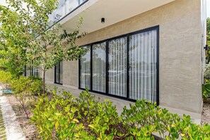 A modern building with large windows and a concrete facade. - 1BR golf suites Apt In Punta Cana at Resort Style Residential w/Artificial Beach (Punta Cana)