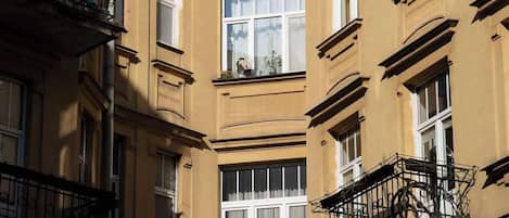 Un edificio de varios pisos con balcones, ventanas amplias y un cielo despejado.