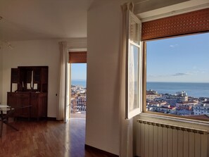 A room with a large window overlooking a cityscape and the sea. - Mare in Vista Salerno - Amalfi Coast Rooftop (Salerno)
