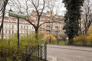 Ein Straßenschild für Konrada Swinarskiego, ein gepflasterter Weg und ein Gebäude mit klassischer Architektur.