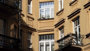 Un edificio de varios pisos con balcones, ventanas amplias y un cielo despejado.