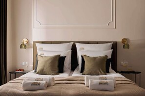 A hotel room with a large bed, two bedside tables, and a wall-mounted light fixture. - Charm & Chic Studio 14.1  | Main Old Town & Planty (Kraków)