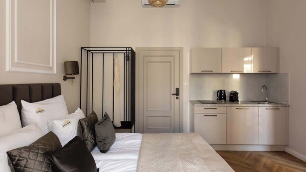 Ein Hotelzimmer mit Bett, einer Küchenzeile und einer Tür zu einem Badezimmer.