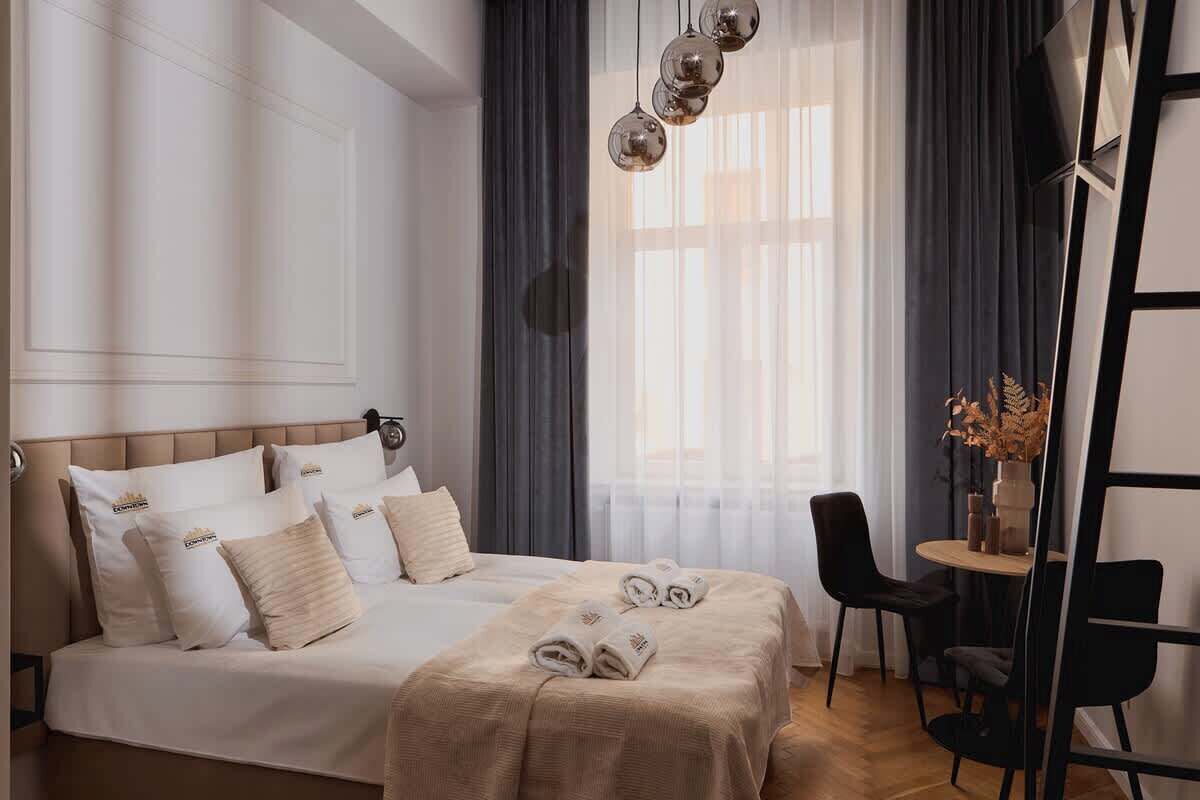 A hotel room with a large bed, a desk, and a chair.