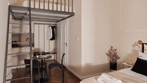 Quarto com uma cama beliche, uma mesa com cadeiras e uma pequena mesa.