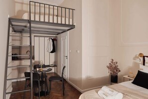 Ein Schlafzimmer mit einem Etagenbett, einem Schreibtisch mit Stühlen und einem kleinen Tisch.