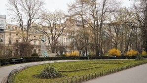 A park with a circular garden, benches, and a statue. - Charm & Chic Studio 14.2 | Main Old Town & Planty (Kraków)