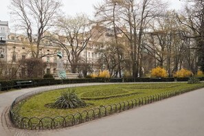 A park with a circular garden, benches, and a statue. - Charm & Chic Studio 14.2 | Main Old Town & Planty (Kraków)
