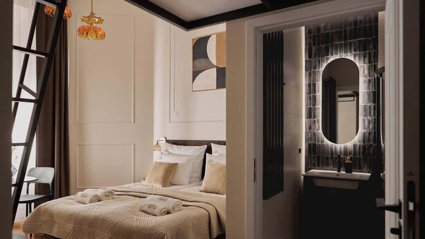 A modern bedroom with a large bed, a bedside table, and a hanging light fixture. - Charm & Chic Studio 14.2 | Main Old Town & Planty (Kraków)