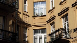 En hörnbildning med många fönster och balkonger, som utmärks av klassiska arkitektoniska detaljer.