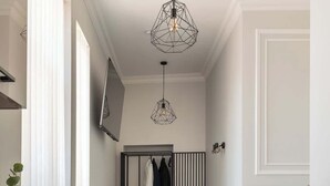 Un dormitorio moderno con cama, mesita de noche y lámpara colgante.