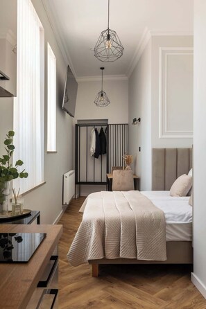 Ein modernes Schlafzimmer mit Bett, Nachttisch und einer Pendelleuchte.
