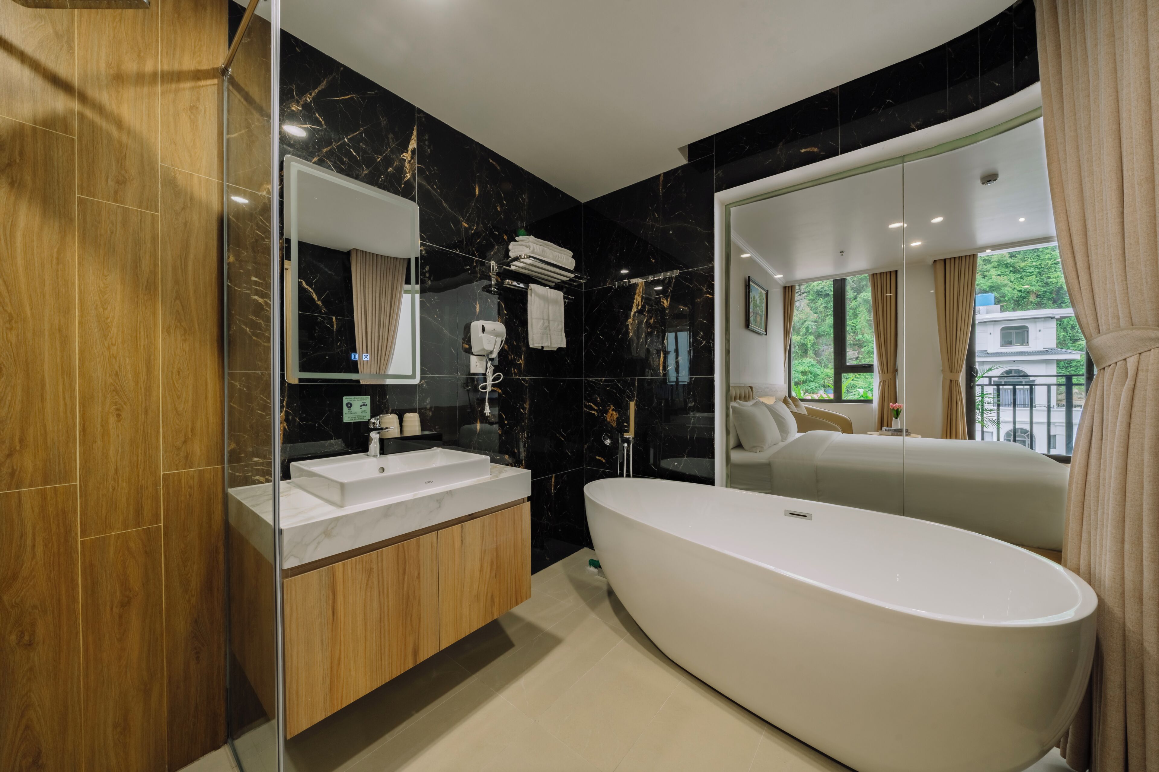 A modern bathroom with a freestanding bathtub, a vanity with a mirror, and a shower area.