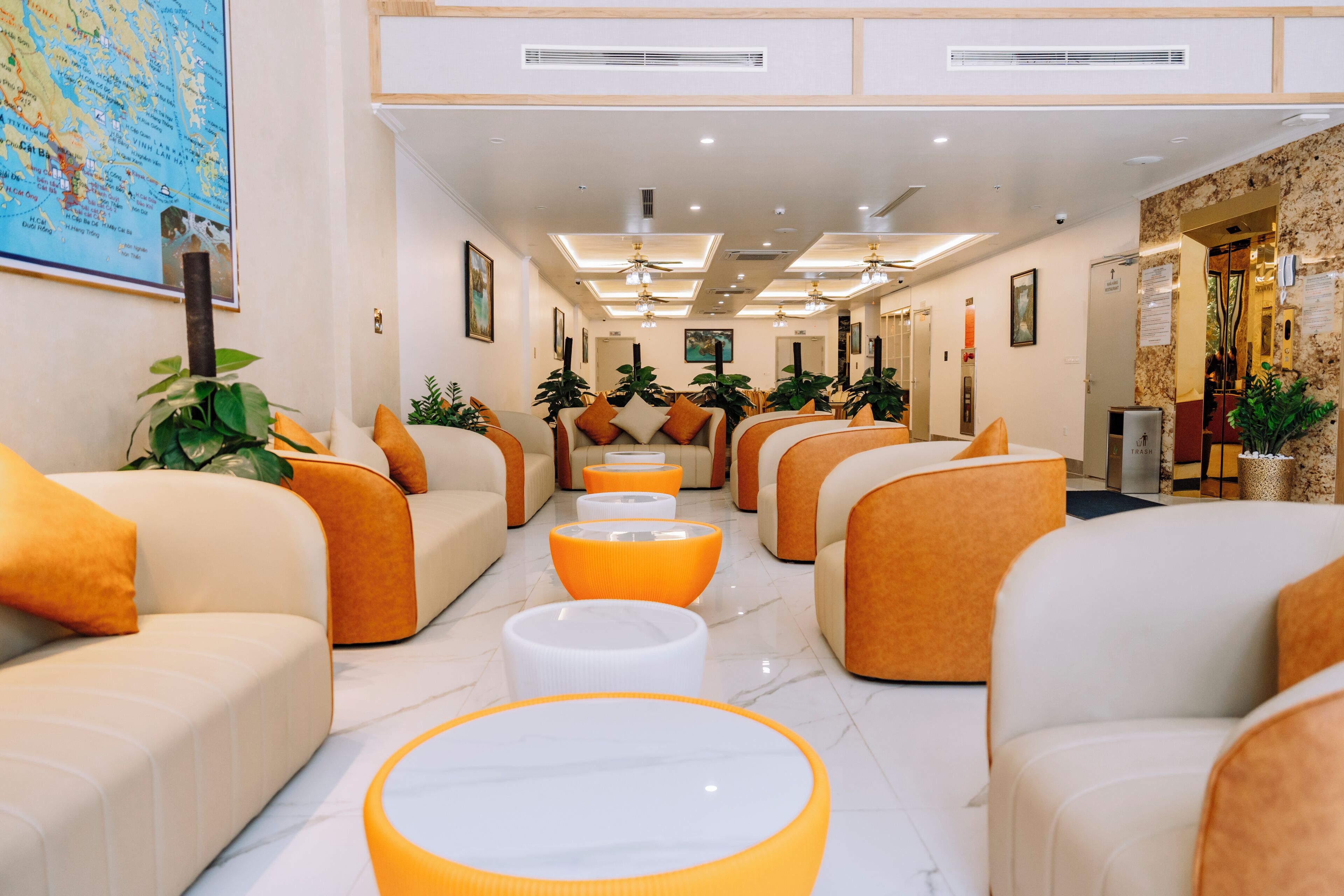 A hotel lobby with seating areas, a reception desk, and a map on the wall.