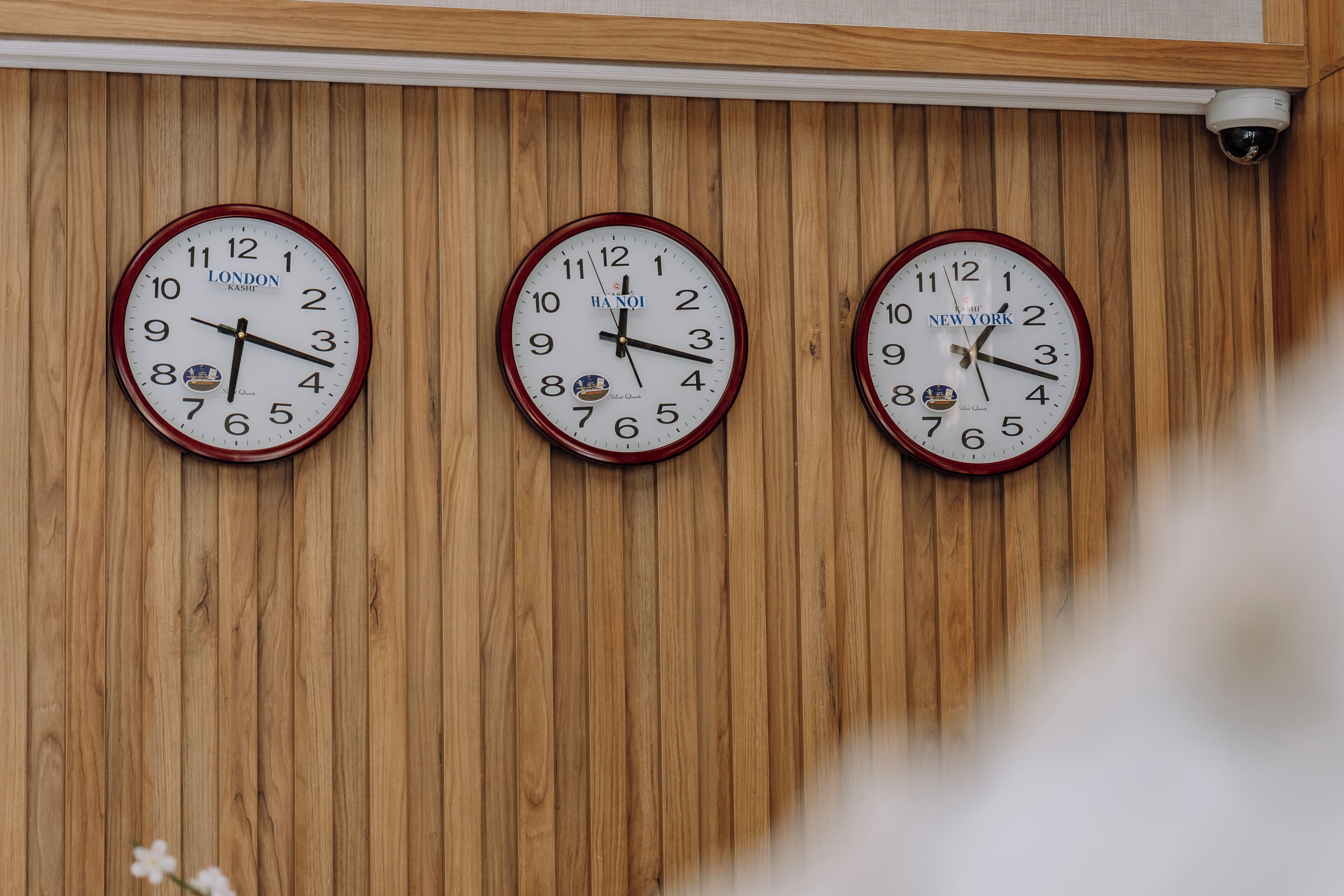 Tres relojes de pared con diferentes marcas y horas indicadas.