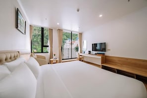 A hotel room with a large bed, a desk, a television, and a balcony with curtains. - Catba Vista Hotel (Hai Phong)