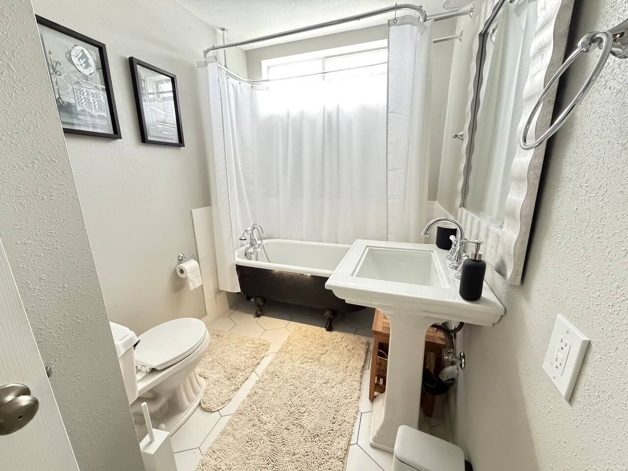 A bathroom with a bathtub, toilet, sink, and a shower curtain.