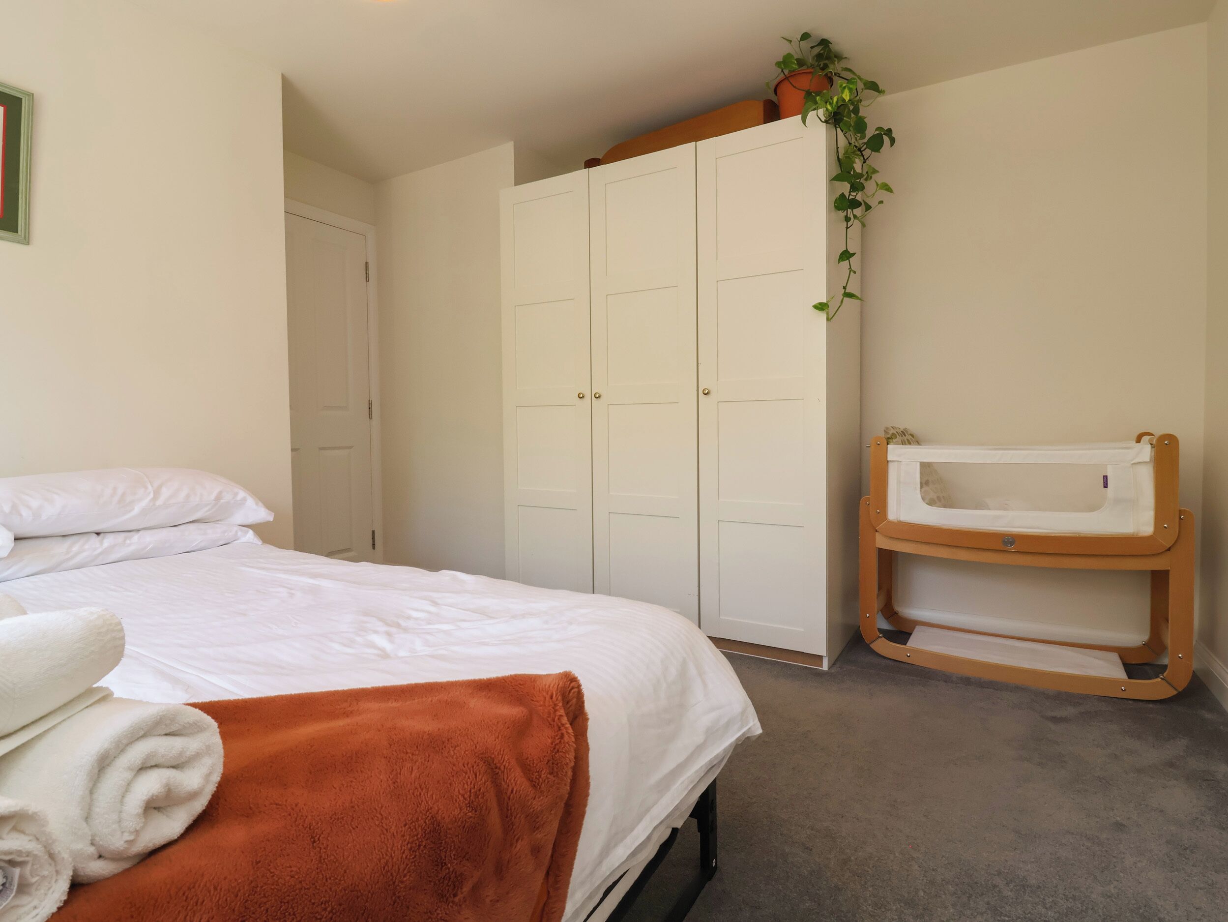 Un dormitorio con cama, armario y cambiador para bebé.