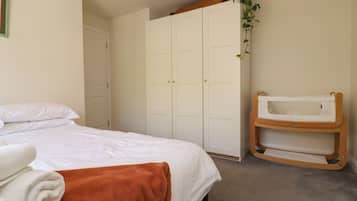 Un dormitorio con cama, armario y cambiador para bebé.