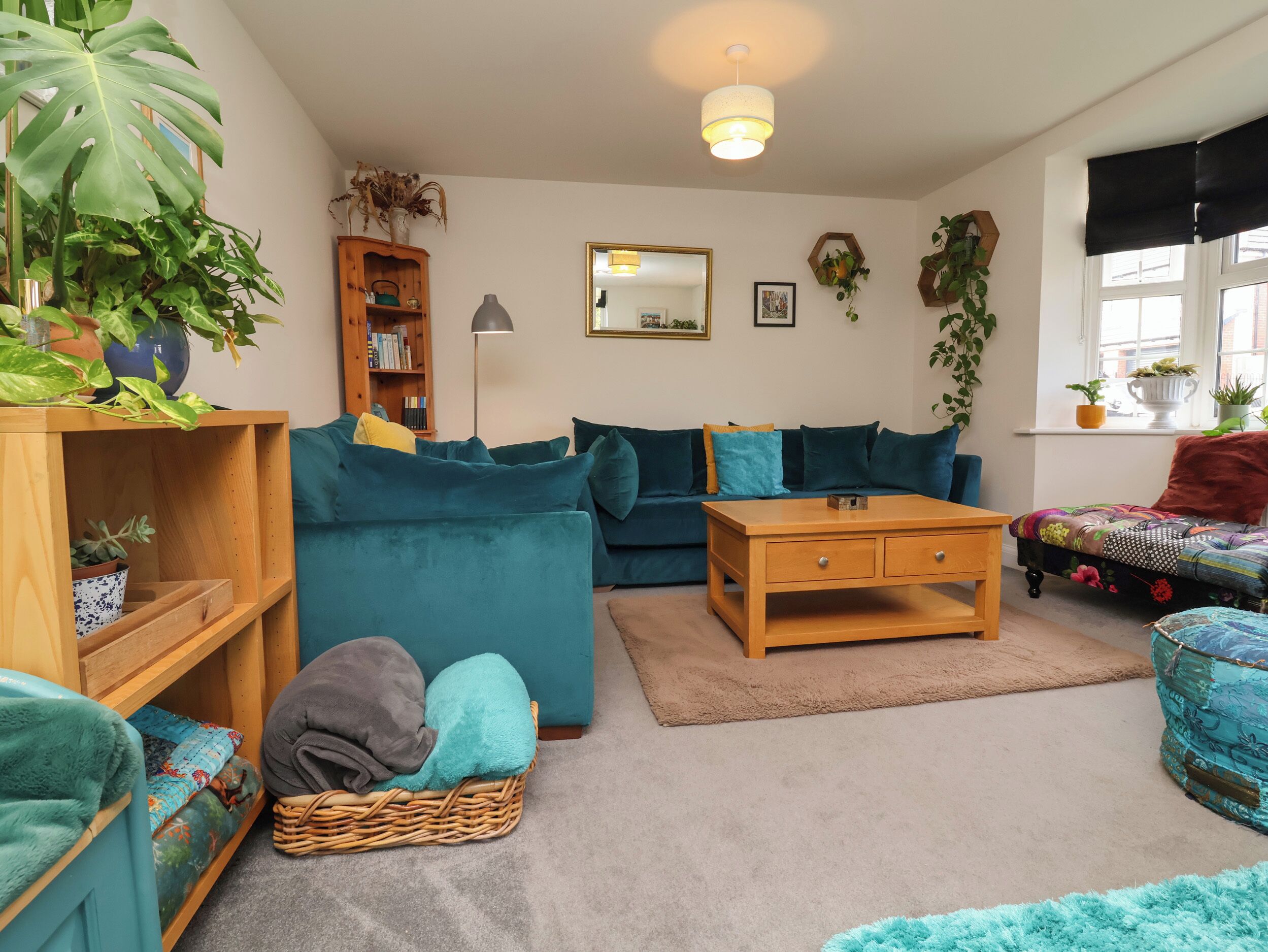 Una sala de estar acogedora con un sofá azul, una mesa de centro de madera y una estantería.