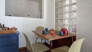 Ein Essbereich mit einem Holztisch, Stühlen und einem dekorativen Fenster mit Glasverzierungen.