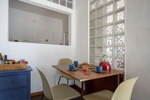 Ein Essbereich mit einem Holztisch, Stühlen und einem dekorativen Fenster mit Glasverzierungen.